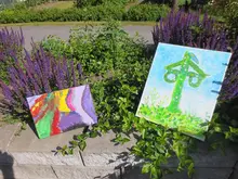 Två målningar som står uppställda ute i naturen.