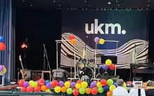 En scen med instrument och färgglada ballonger på sig.