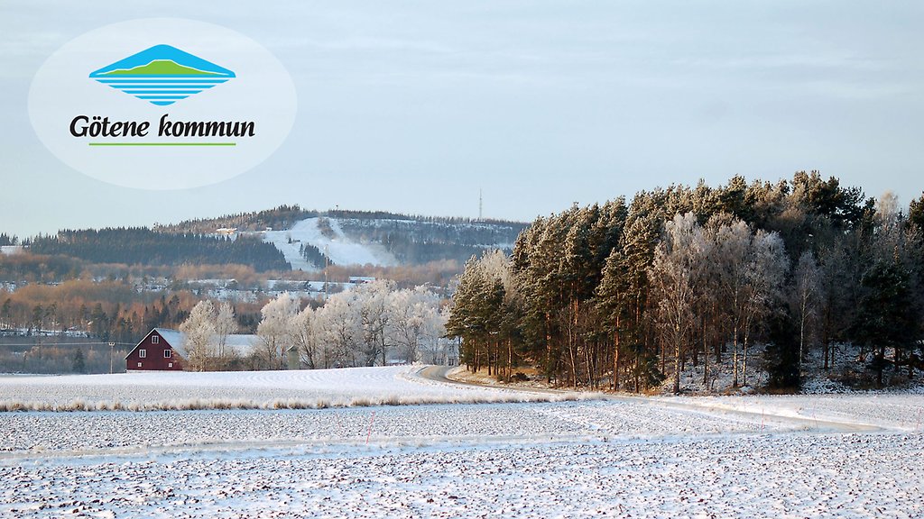 Frostig åker och skog. I bakgrunder skymtar ett snöigt berg.