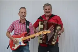 Två män som håller i dragspel och gitarr.
