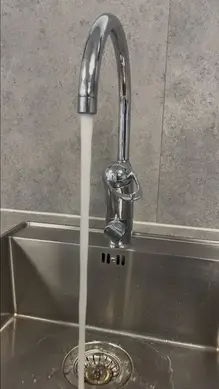 Rinnande vatten ur en vattenkran i ett kök. 