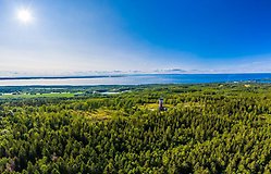 plansch för höstrundan på kinnekulle. en kvinna smider ett järn.