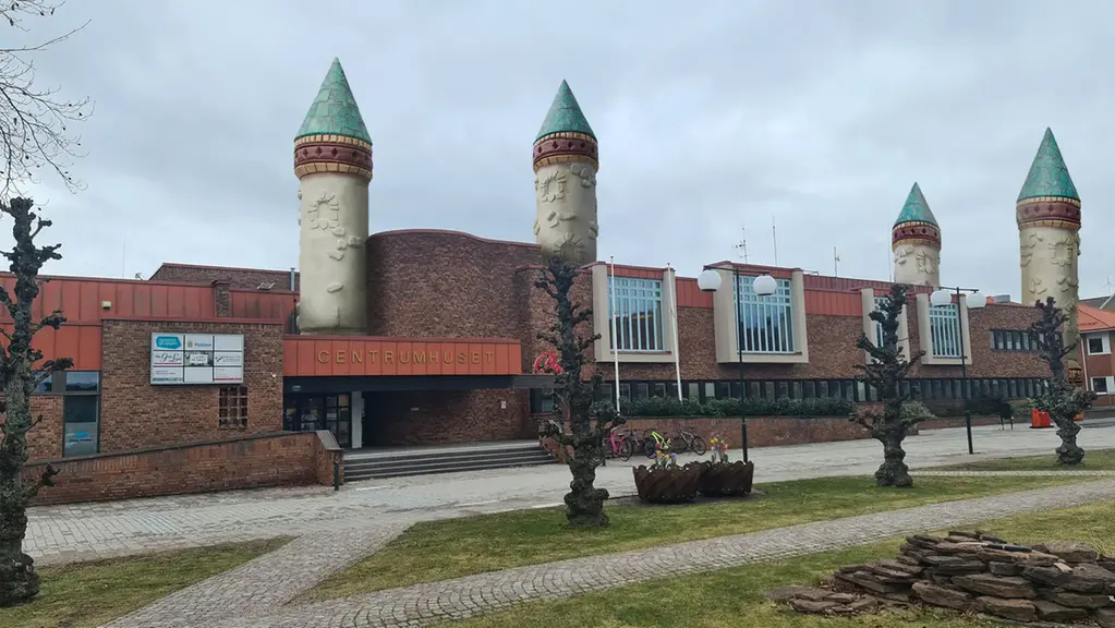 Kommunhuset i Götene, en stor tegelbyggnad som nu har fyra torn. Två över entrén och två i hörnen. 